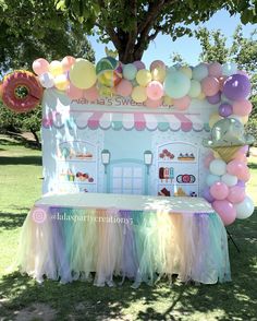 an ice cream stand decorated with balloons and pastel colors