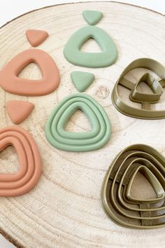 various shapes and sizes of cookie cutters on a wooden board