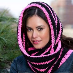 a woman wearing a pink and black crocheted scarf