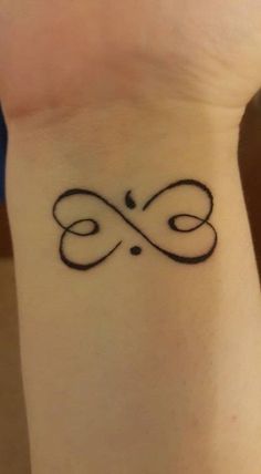 a wrist tattoo with an infinite symbol on it