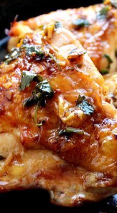 two pieces of chicken covered in sauce and herbs