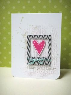 a card with a pink heart in a black and white frame on a green polka dot background