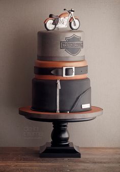 a three tiered cake is decorated with motorcycles and leathers on the top layer