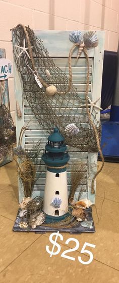 a blue and white lighthouse sitting on top of a wooden crate with seaweed attached to it