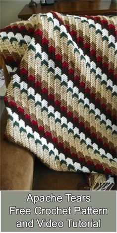 a crocheted blanket sitting on top of a couch next to a brown chair