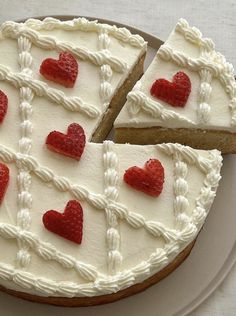 a cake with white frosting and red hearts on it