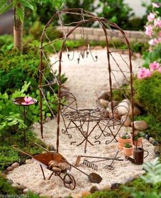 an outdoor garden with various plants and pots on the ground, including a metal gazebo