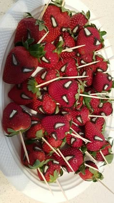 strawberries are arranged on skewers with toothpicks