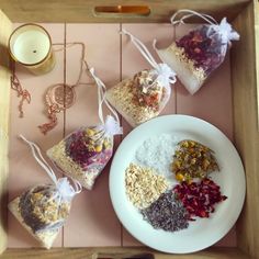 four bags of granola sitting on top of a white plate next to a candle