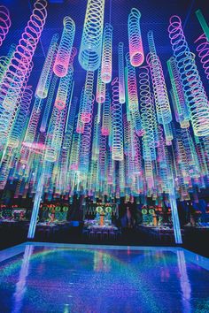 colorful lights are hanging from the ceiling above a pool