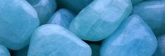 many blue rocks are stacked together in this close - up photo with the focus on one rock