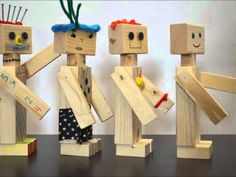 four wooden toy figures standing next to each other