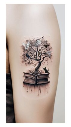 a woman's thigh with an open book and tree on it