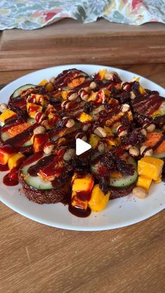 a white plate topped with cucumbers and other food on top of a wooden table