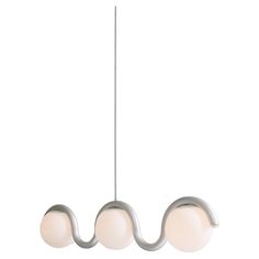 three lights hanging from the ceiling on a metal rod with two white balls attached to it