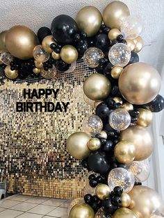 a happy birthday balloon arch with black and gold balloons in the shape of an arch