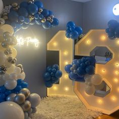 blue and white balloons in the shape of numbers are on display at a children's birthday party