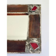 a mirror that has been made out of wood and metal with red squares on it