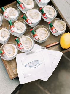 there are many glasses with ice cream and lemons in them on a tray next to an orange