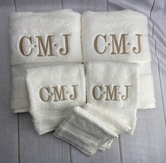 four white towels with the letters cmj and j on them