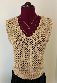 a crocheted top on a mannequin with a necklace hanging from it's neck