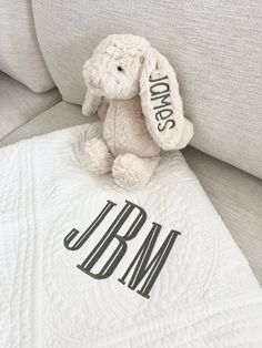 a stuffed animal sitting on top of a white couch next to a pillow that says mr and mrs