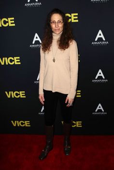 a woman standing on a red carpet in front of a black and yellow sign that says vice