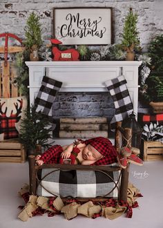 a baby is laying in a bed with christmas decorations on the fireplace mantel behind it