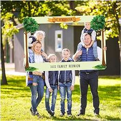 a family posing for a photo in front of a sign with the name of their home