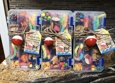 three plastic containers filled with assorted candies on top of a counter next to a brick wall