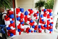 the letters are decorated with red, white and blue balloons