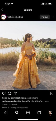 a woman in a yellow dress standing next to a lake