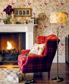 a living room filled with furniture and a fire place next to a wallpapered wall