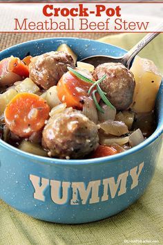 a blue bowl filled with meatballs and veggies on top of a table