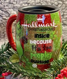 a red and green coffee mug sitting on top of a christmas tree