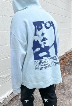 the back of a person wearing a white hoodie with a blue graphic on it