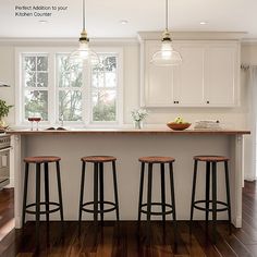 three stools sit at the center of a kitchen island