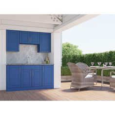 an outdoor kitchen with blue cabinetry and white walls, along with wicker chairs