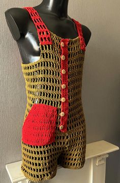 a mannequin wearing a crocheted bodysuit with red shorts on it