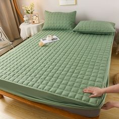 a person reaching for a mattress on the floor