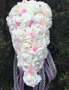 the bridal bouquet is made up of white and pink flowers with lace on it