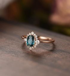 an oval shaped blue and white diamond ring on top of a wooden table with blurry background