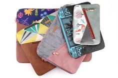 several wallets are stacked on top of each other in different colors and patterns,