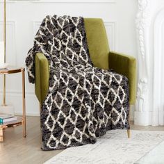 a green chair with a blanket on it