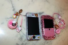 three cell phones with hello kitty charms on them