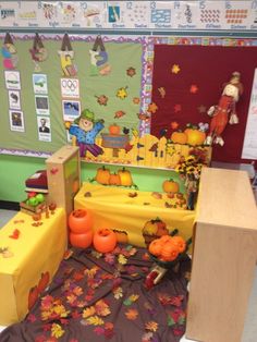 a room filled with pumpkins and decorations on top of a bed in front of a bulletin board