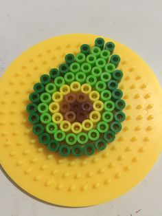 a yellow and green object sitting on top of a yellow plate with holes in it