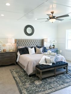 a bedroom with a bed, dressers and ceiling fan in it's center