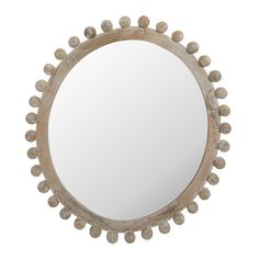 a round mirror that has some balls on the rim and is made out of wood