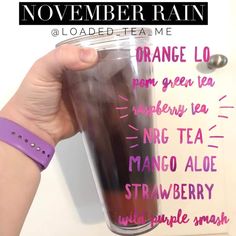 a hand holding a cup with the words november rain written on it and an orange tea